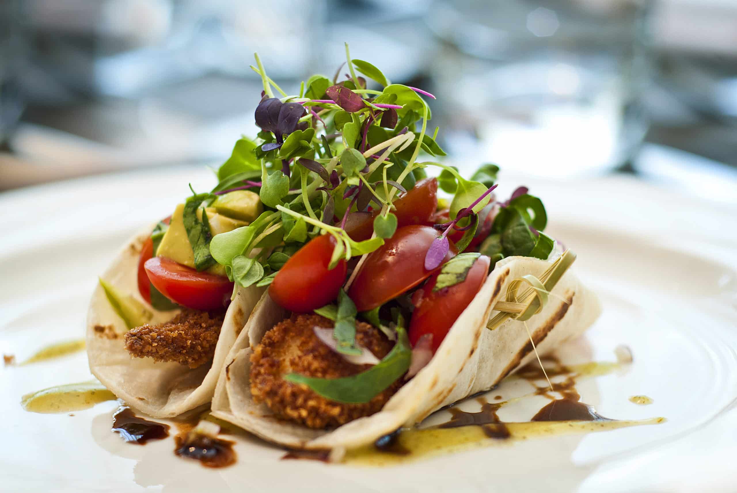 Two tacos on a plate garnished with fresh greens. Independent Retirement Community.