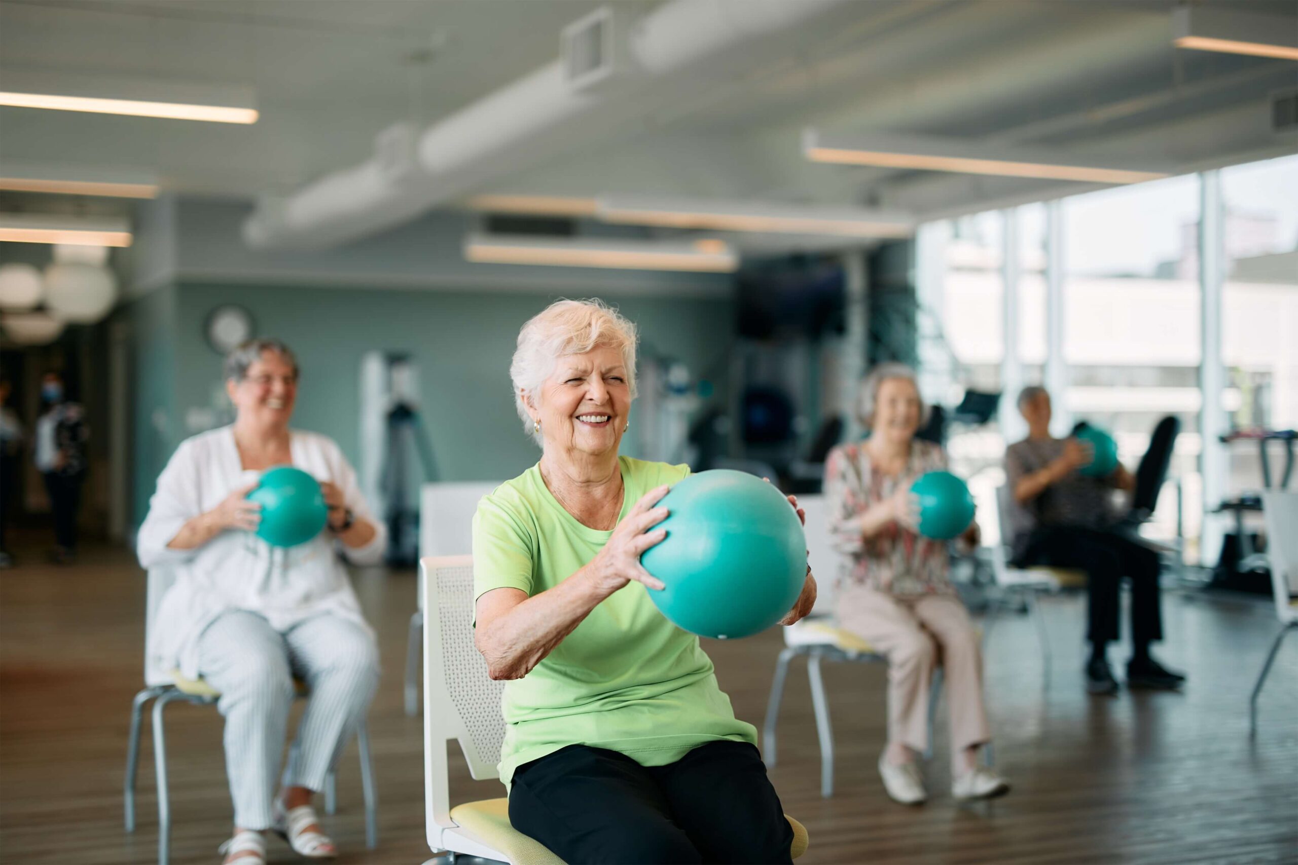 Senior residents exercising with exercise balls. Best Years. Independent Senior Living.