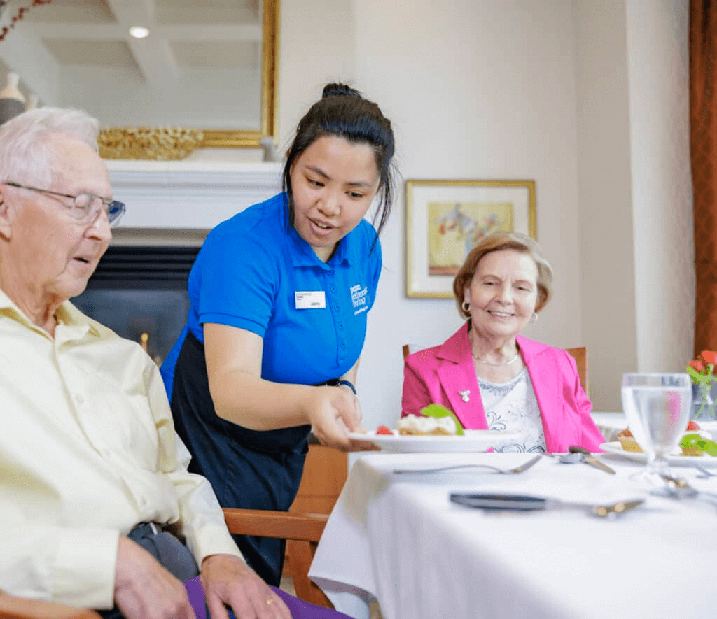 A woman serving two residents in a restaurant