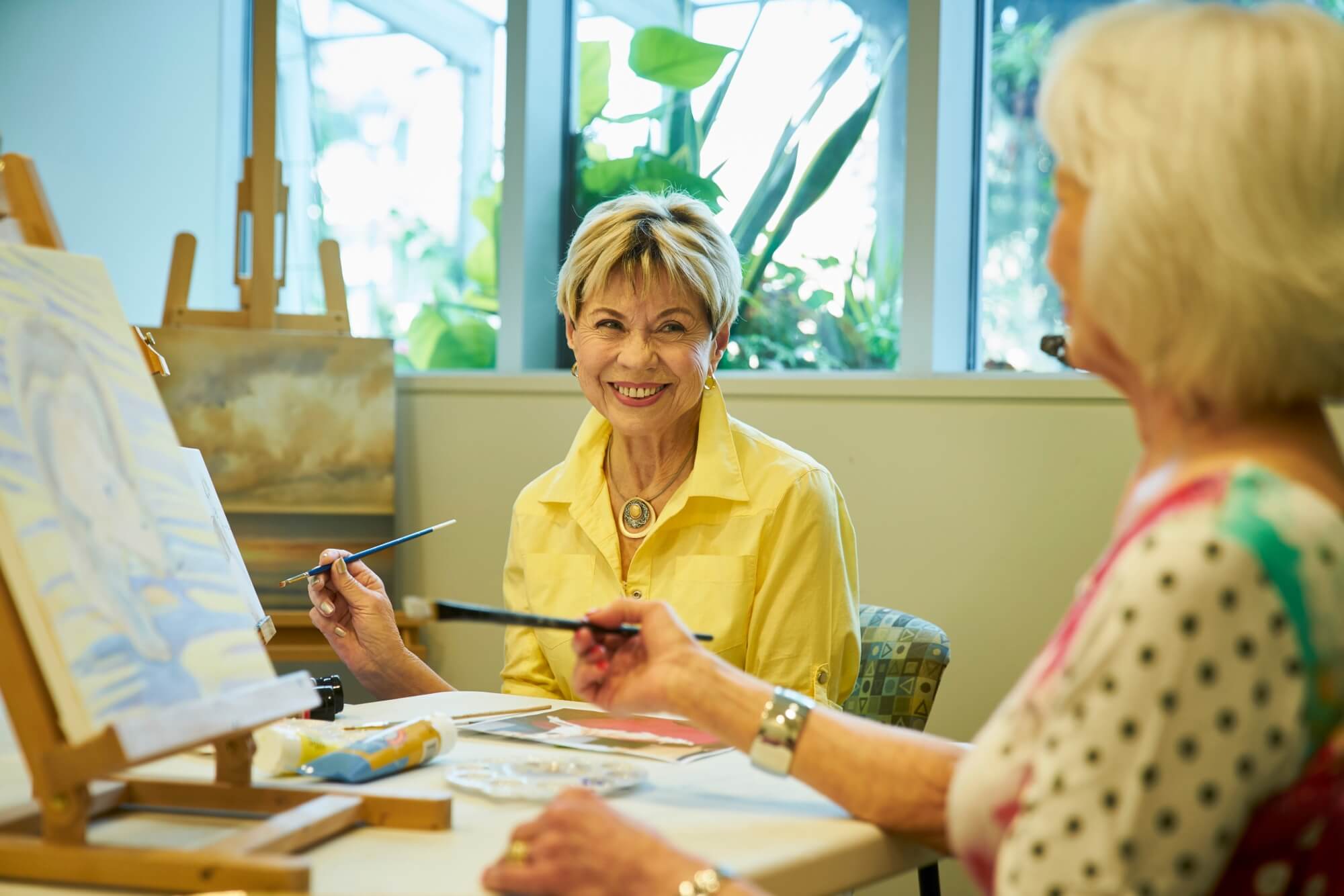 Two residents at a painting class