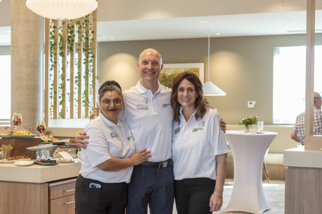Three employees standing together and smiling